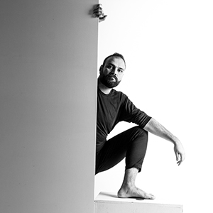 Schwarz-Weiß Porträt, der Künstler Bahzad Sulaiman, um die Ecke schauend © Christoph Holz